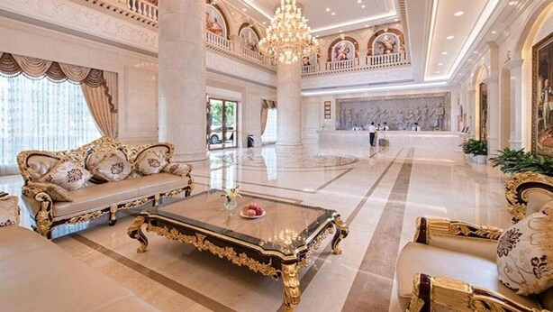 A luxurious lobby with ornate furniture, a grand chandelier, and classical artwork. - Vienna International Hotel (Maoming)