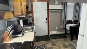 A kitchen with wooden cabinets, a stove, a sink, and a refrigerator. - Just Like Being At Home- Newly Renovated Unit (North Troy)