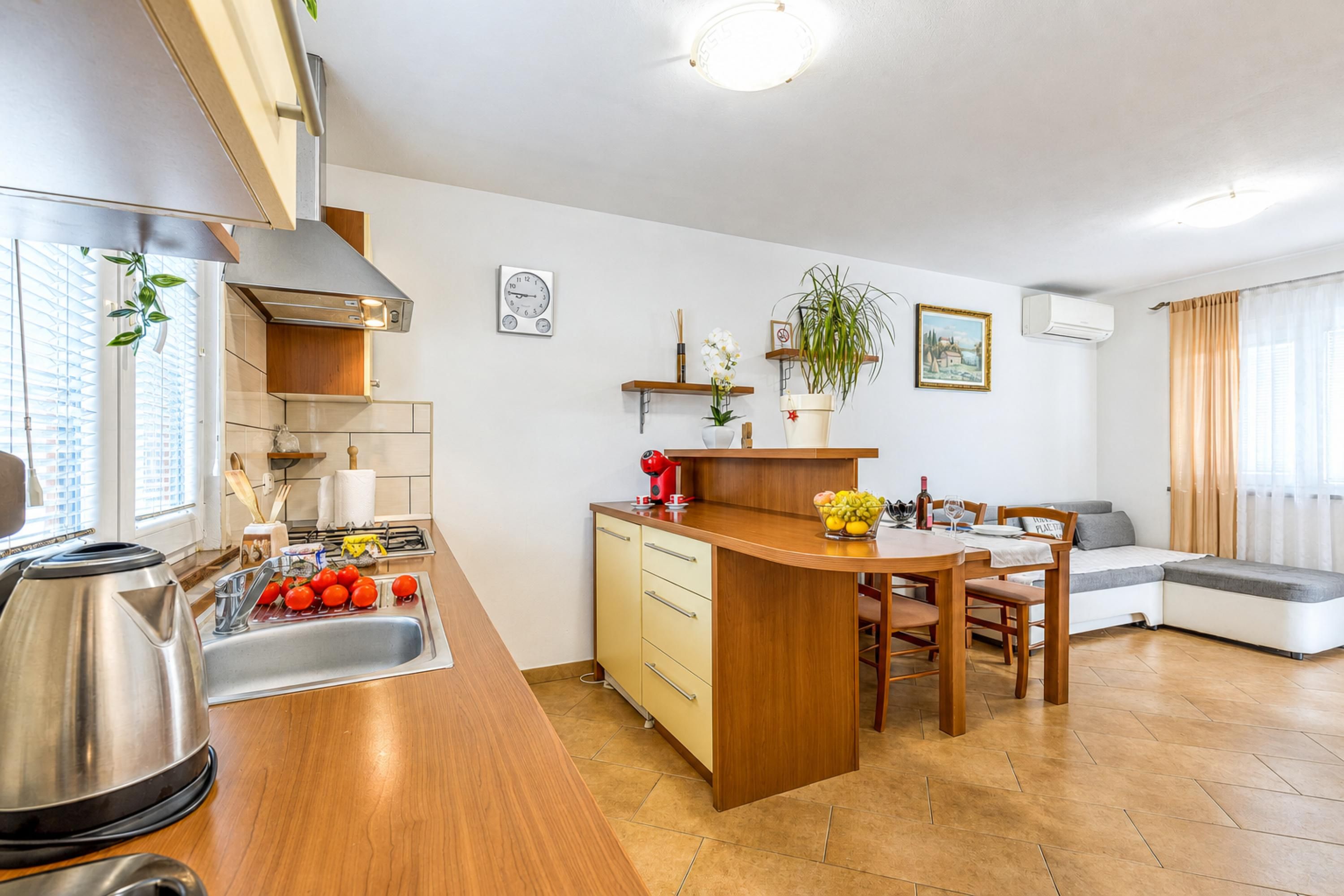 A modern kitchen with a sink, stove, and a dining area with a table and chairs.