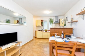 A modern kitchen with a dining area, a TV, and a mirror. - House In The Vineyards Ankaran (Ankaran)