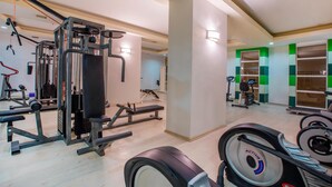 Une salle de sport équipée de divers appareils d’entraînement, notamment des appareils de musculation et des appareils de cardio.