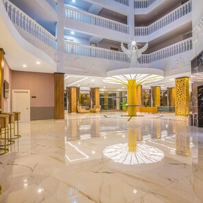 A multi-level hotel lobby with marble flooring, a central decorative light fixture, and a seating area with chairs. - Meridia Beach Hotel (Alanya)