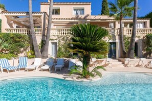 A poolside area with lounge chairs and a palm tree.