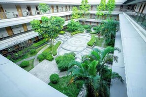 A multi-level courtyard with greenery, a circular garden, and a building with balconies. - Perthden (Hanging) Gardens Hotel (Shenzhen)