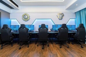 Una sala conferenze con sei sedie da ufficio nere, un tavolo lungo e sei monitor computer.