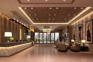 A spacious lobby with a reception desk, seating area, and large windows offering a view of the cityscape.