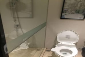A bathroom with a toilet, a shower, and a glass partition. - Zhujiang New Town Hampton Hilton (Guangzhou)