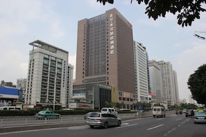 A multi-story building with a prominent entrance, likely a hotel or office building, surrounded by other high-rise structures. - Zhujiang New Town Hampton Hilton (Guangzhou)