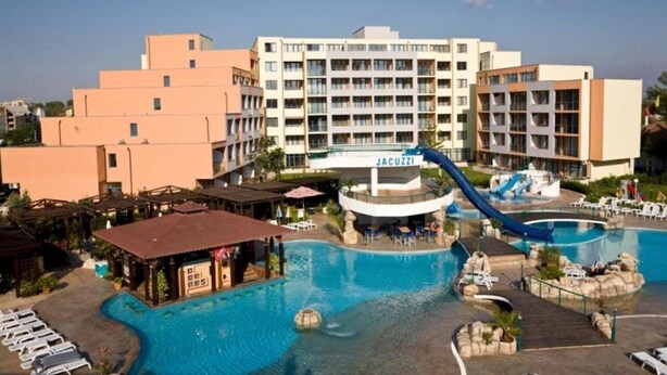 A hotel with a swimming pool, a water slide, and a bar area.