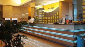 A reception desk with a modern design, featuring a glass partition and a digital display.