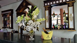 A bar area with a vase of flowers and a champagne bucket. - Palms Hotel Club (Aarab Sebbah Ziz)