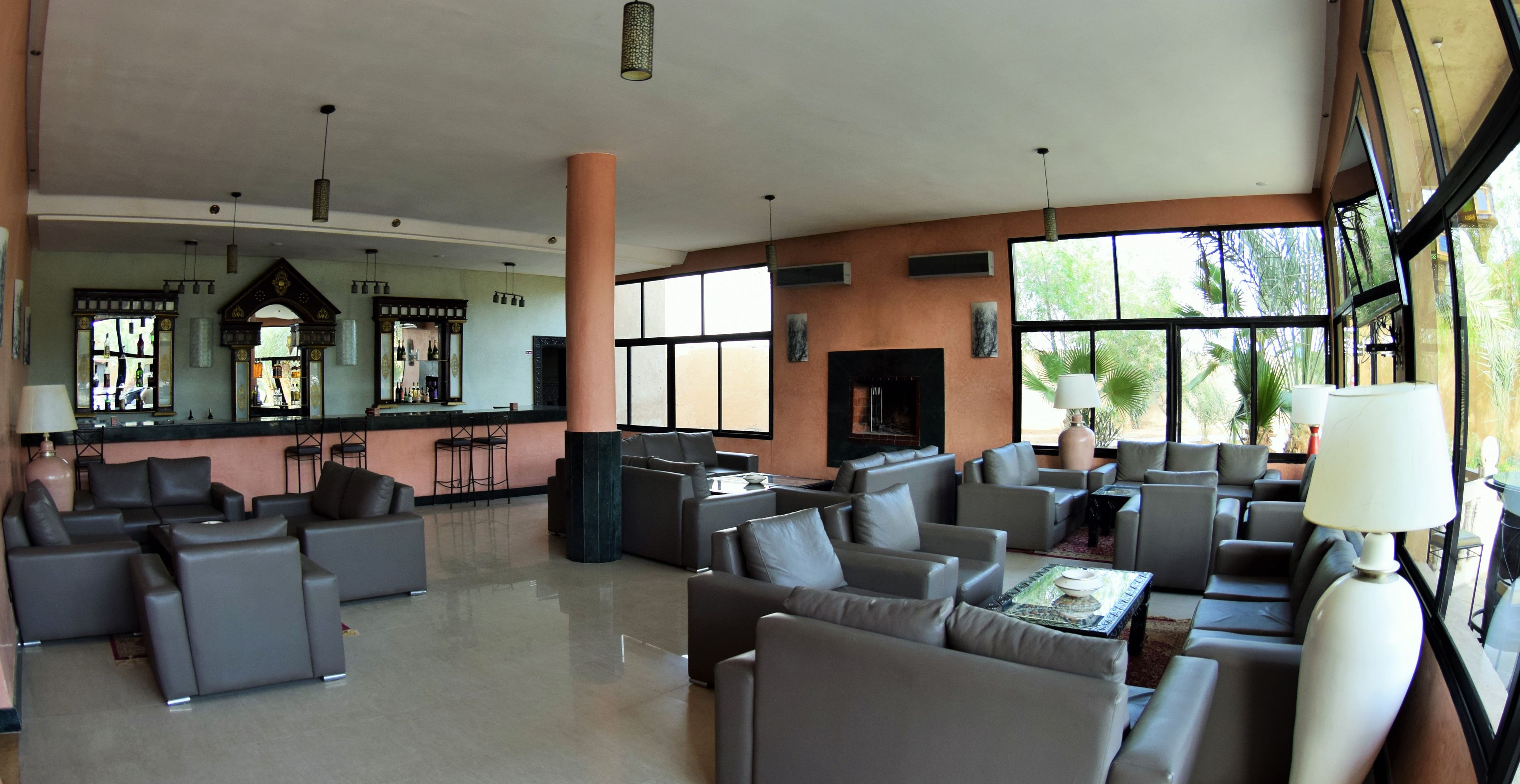 Um hall amplo com várias áreas de estar, um bar e grandes janelas que oferecem muita luz natural.