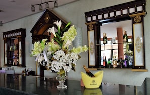 A bar area with a vase of flowers and a champagne bucket. - Palms Hotel Club (Aarab Sebbah Ziz)
