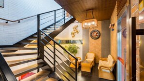 A modern interior with a staircase, wicker chairs, and a dartboard. - Fudi Hotel (Shanghai)