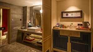 A modern bathroom with a large mirror, a sink, and a vanity with toiletries. - Yongkang Huihe Hotel (Yongkang)
