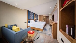 A hotel room with a bed, a sofa, a glass table, and a wooden wardrobe. - Yongkang Huihe Hotel (Yongkang)