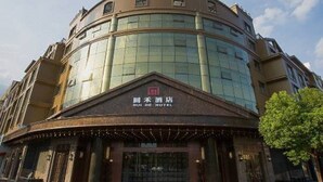 A hotel with a curved facade, large windows, and a sign indicating it is the HUI HE HOTEL. - Yongkang Huihe Hotel (Yongkang)