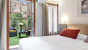 Une chambre d’hôtel avec un lit, une vue sur l’extérieur et une petite table avec une plante.