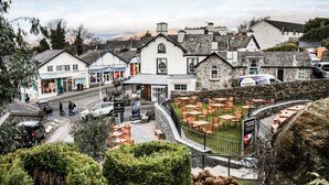 A town with stone buildings, outdoor seating, and a sign for 'Winter's Brew'. - The Angel Inn - The Inn Collection Group (Windermere)