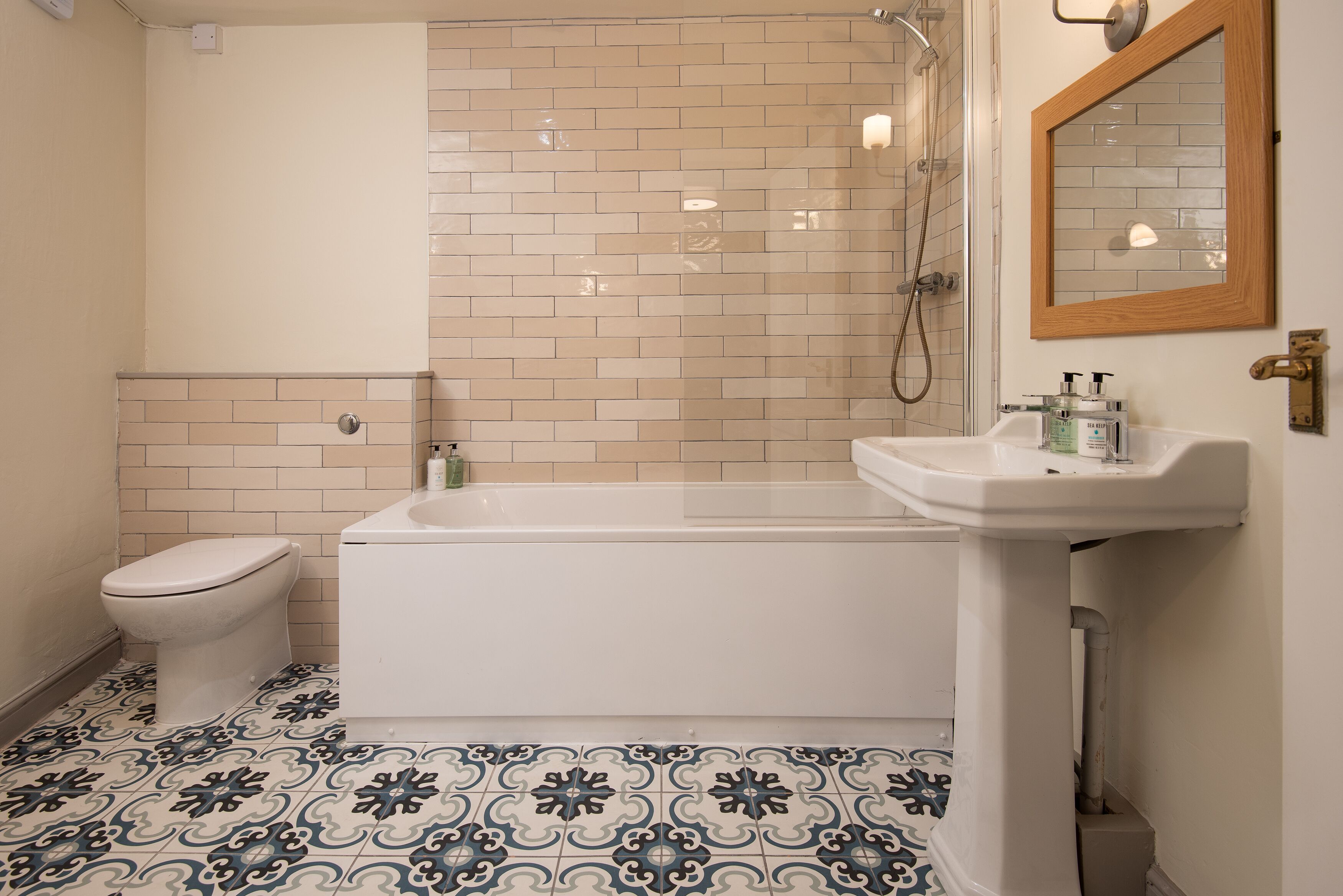 A bathroom with a toilet, bathtub, and sink.