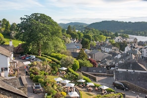 A riverside town with a café area, stone buildings, and a view of the river.