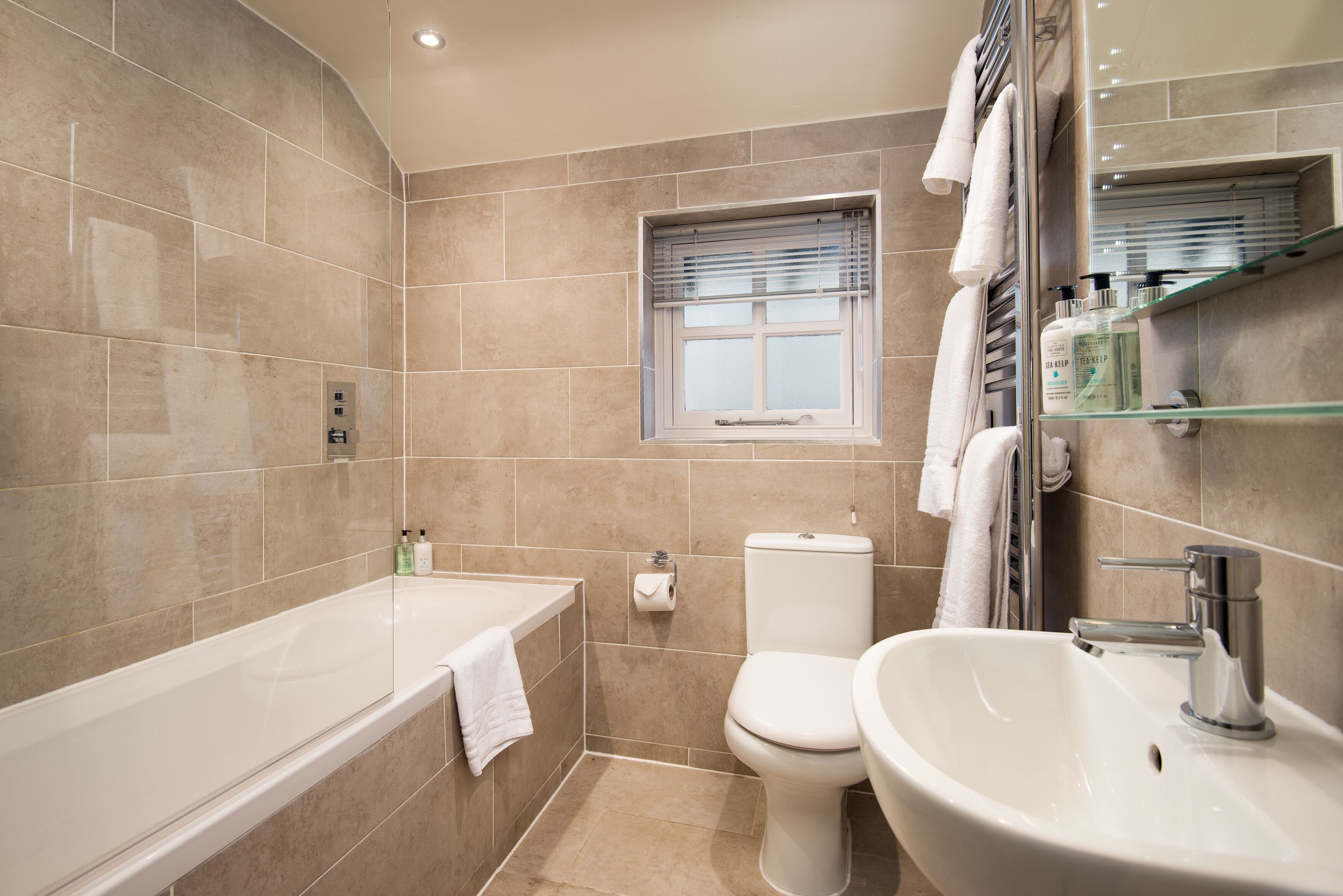A modern bathroom with a bathtub, toilet, and sink.