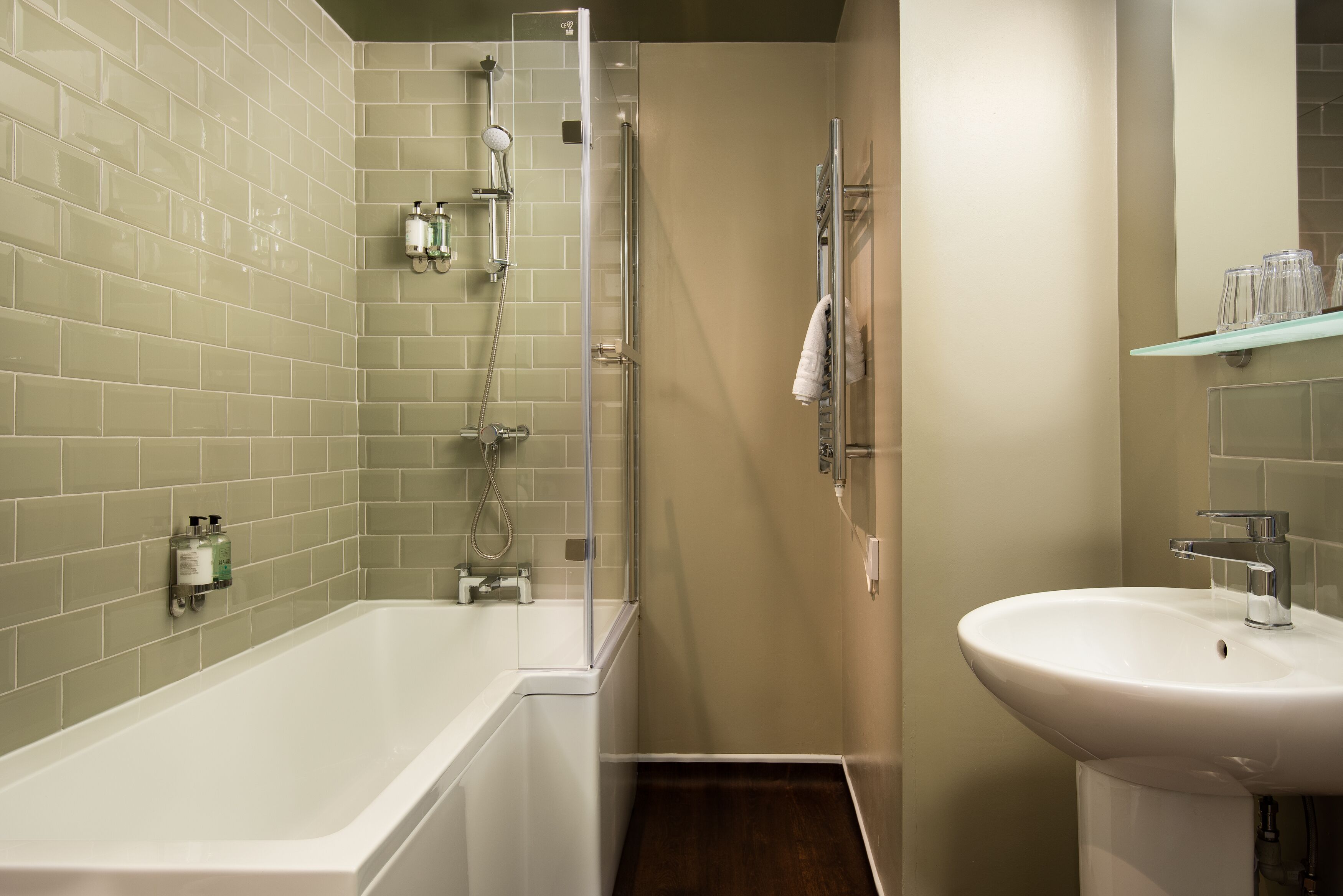 A bathroom with a bathtub, shower, and sink.