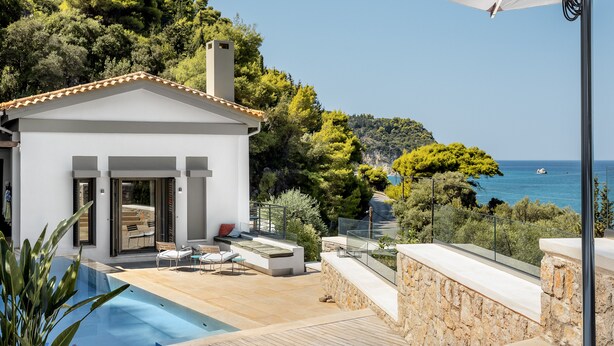 Une villa moderne dotée d’une piscine, d’un espace extérieur aménagé et offrant une vue sur la mer.