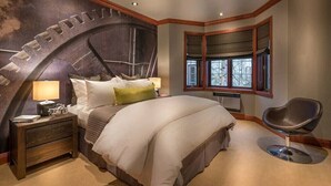 Une chambre avec un grand lit, une table de chevet, une chaise et une fenêtre donnant sur un beau paysage.