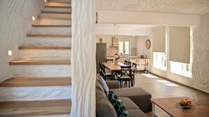 A modern interior with a staircase, a dining area, and a kitchen. - Charming stone house Villa Pepina (Risika)