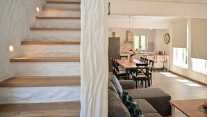Un interior moderno con una escalera, un comedor y una cocina.