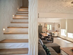 Ein modernes Interieur mit einer Treppe, einem Essbereich und einer Küche.