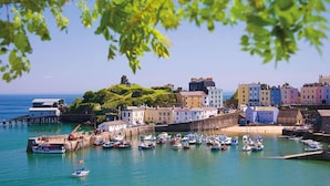 A coastal town with a harbor, buildings, and a pier. - Sea Legs (Tenby)