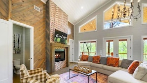 A cozy living room with a fireplace, a sofa set, and a checkered armchair.