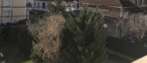 A residential area with houses, a small bridge, and mountains in the background.