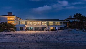 A beachfront property with a large, multi-story house featuring balconies and large windows. - 3Bedroom Beachfront Condo-Gulf View-On the Sand! (Indian Rocks Beach)