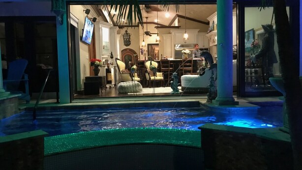 A pool area with a fountain, indoor seating, and a view of the interior space.