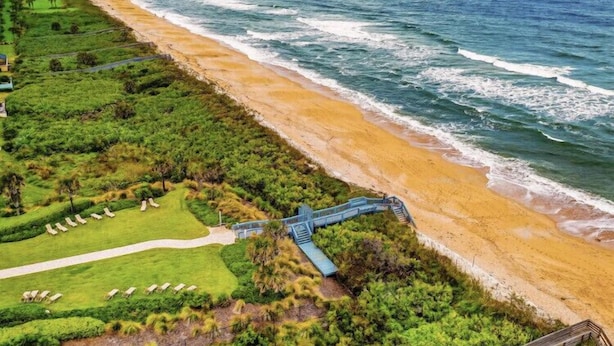 Une station balnéaire dotée d’une plage, d’un sentier pédestre et d’un pont reliant la propriété à la plage.