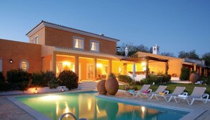A two-story house with a swimming pool, outdoor seating, and a well-lit entrance. - Villa Faustine, huge lawn, sea view, kid play area (Boliqueime)