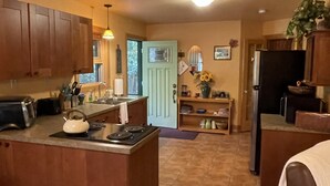 Una cocina amplia con una isla central, armarios de madera y un comedor con mesa y sillas.