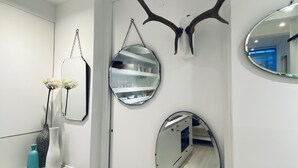 A bathroom with a white vanity, a mirror, and a decorative antler.