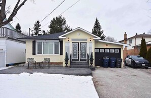 Charming single-story home with a gabled roof and decorative glass entrance.