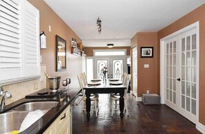 Enjoy meals in this stylish dining area with a long table for four, adjacent to a fully equipped kitchen.