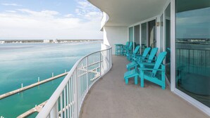 Un balcon avec des chaises turquoise et une vue sur l’océan.