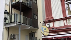 A multi-story building with a ground-floor commercial space, including a visible sign for 'Hotel Traube' and a 'Brasserie'. - Wildbach City Apartments (Zell am See)