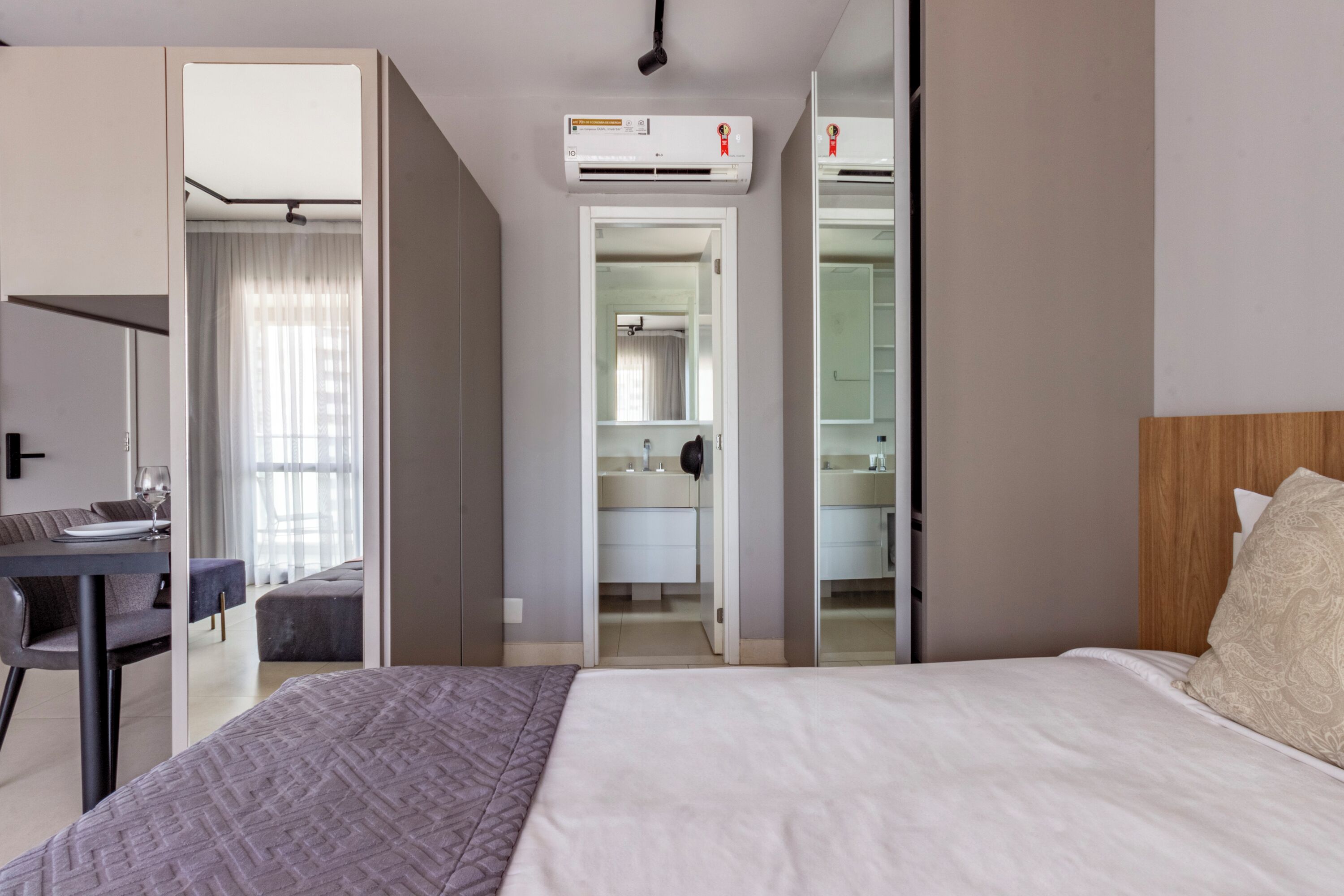 Een moderne hotelkamer met een groot bed, een bureau en een badkamer die door een open deur zichtbaar is.