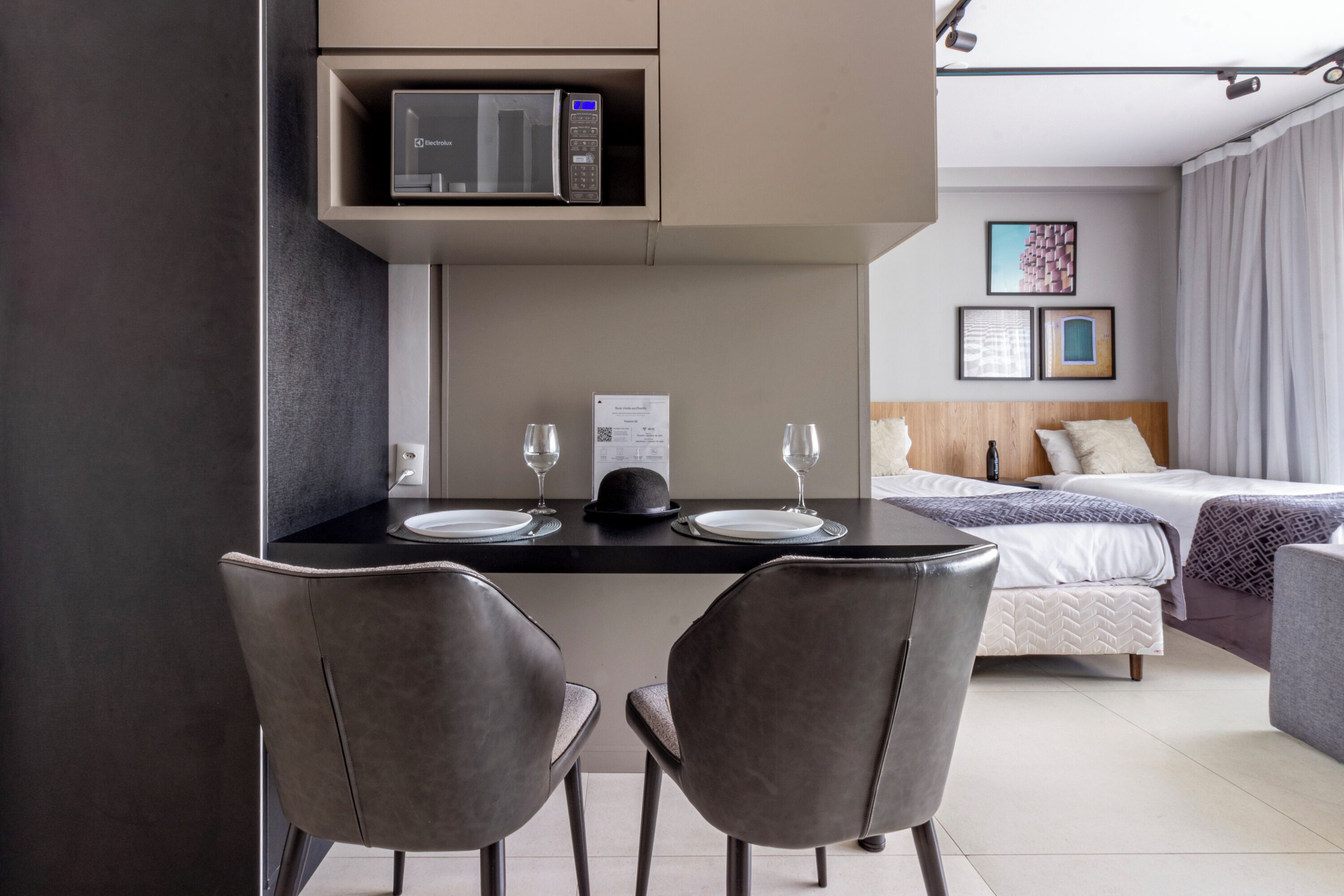 Una habitación de hotel moderna con comedor, cama y vistas a la ciudad.