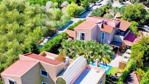 A multi-story residential building with a red-tiled roof, multiple balconies, and a swimming pool. - Prestige Residence Rhodes - accommodating up to 22 guests! (Ialisos)