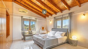 A bedroom with a bed, bedside table, and a lamp. - Prestige Residence Rhodes - accommodating up to 22 guests! (Ialisos)