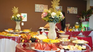Una mesa de buffet con diferentes alimentos y jarrones decorativos.